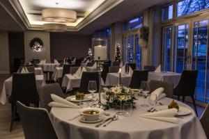 米兹多洛杰Villa Bravo & SPA的一间设有白色桌椅和窗户的用餐室