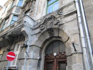 布达佩斯Carpe Noctem Hostel的带有棕色门和红色停车标志的建筑