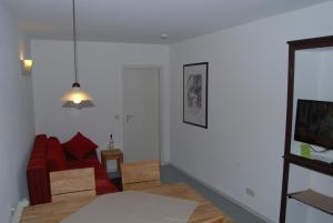 Gau-AlgesheimKronenhof - Wein und Ferien的客厅配有红色沙发和电视