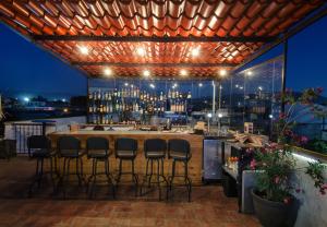 瓦哈卡市Comala Bed & Breakfast的酒吧,屋顶上,有酒吧凳