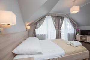 亚斯塔尔尼亚Willa Przystań的卧室配有一张大白色床和窗户