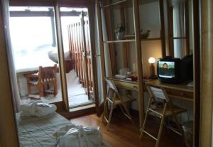 塞斯特雷Il Fraitevino hotel bed & breakfast的客房设有一张桌子、一台电视和一张桌子及椅子