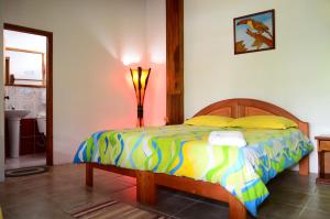 普约拉斯帕尔马斯旅馆的一间卧室配有一张带五颜六色棉被的床