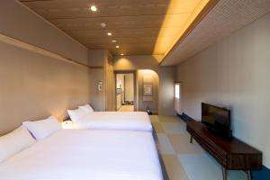 京都麦K之家酒店的酒店客房设有两张床和电视。