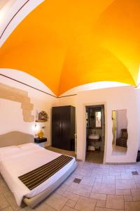 莱切维蒂19号酒店的一间卧室设有一张床和一个橙色的大天花板