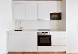 巴塞罗那Decô Apartments Barcelona-Born Apt.的白色的厨房配有白色橱柜和水槽