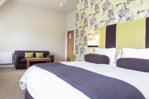 伯恩茅斯格林别墅酒店的酒店客房设有一张大床和一张沙发。