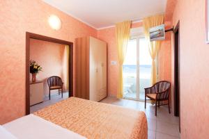 切塞纳蒂科凯撒酒店的一间卧室配有一张床,享有海景