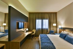 圣安德雷Hilton Garden Inn Santo Andre的配有一张床和一张书桌的酒店客房