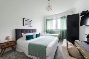 拉罗谢尔Villa Verde La Rochelle的酒店客房设有一张大床和一张沙发。