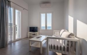 阿波罗尼亚Milos Waves Luxury Apartments的白色的客厅配有椅子和桌子