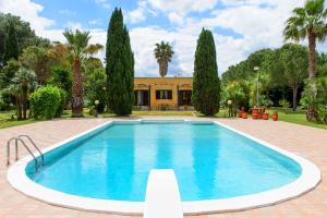 梅萨涅Villa Delle Lantane的一座树木繁茂的房屋前的游泳池