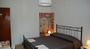 比萨Casa Giulia的一间卧室配有一张床和一张带台灯的桌子