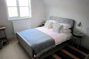 奥福德Crown Cottage - Prime Orford Location的一间卧室配有一张大床和枕头