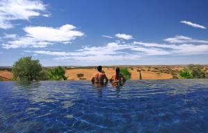 莫拉维尔多马纳提奥酒店的两个人站在游泳池的水面上
