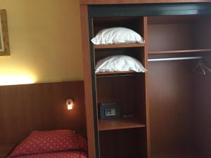 亨克维内酒店的卧室书架上的两个白色枕头