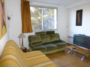 勒索兹GRANDE CHAUME A 42的带沙发和电视的客厅