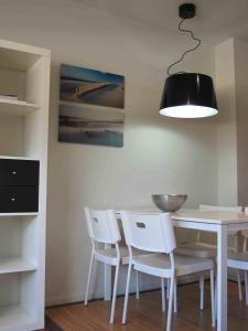 艾利亚德亚罗萨Apartamento playa Isla de Arosa的一间设有白色桌子和白色椅子的用餐室