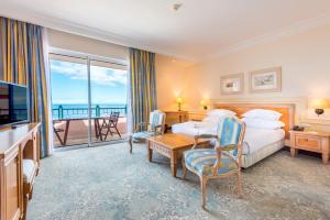 丰沙尔Pestana Royal All Inclusive Ocean & Spa Resort的酒店客房设有一张床和一个阳台。