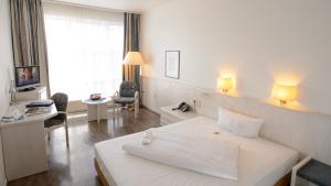 亨内夫亨内夫欧罗公园酒店的酒店客房设有一张白色大床和一张书桌