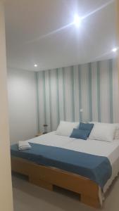 普拉亚Apto T1 Comfort的一间卧室配有一张带蓝色毯子的大床