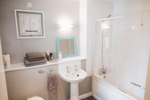 贝尔法斯特Comfortable Belfast city centre apartment的白色的浴室设有水槽和淋浴。