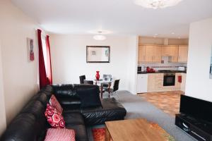 贝尔法斯特Comfortable Belfast city centre apartment的客厅配有真皮沙发和桌子