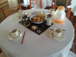 诺诺Las Esmeraldas的一张带杯子和一盘食物的白色桌子