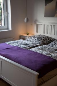 Allendorf an der LumdaFerienwohnung Helbig的卧室内的一张带紫色棉被的床