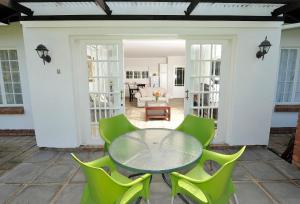 Lidgetton里特伍德旅馆的一个带玻璃桌和绿色椅子的庭院