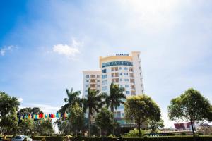 邦美蜀达克若珂酒店的一座高大的建筑,前面有棕榈树