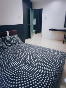 拉布安甘加拉之家度假屋的一间卧室配有一张带黑白色棉被的床