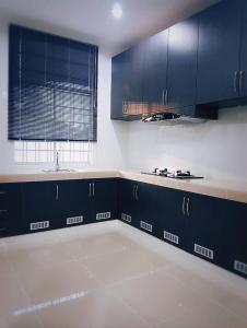 拉布安甘加拉之家度假屋的一间空厨房,内配蓝色橱柜和水槽