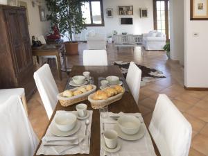萨韦纳河畔圣拉扎罗洛坎达卡斯特尔德布里蒂乡村民宿的餐桌、白色椅子和餐桌,上面有食物