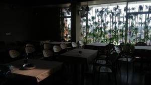 贝尔高姆Navaratna Palace的一间设有桌椅的用餐室,种植了棕榈树