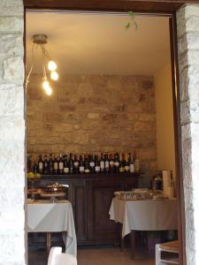 阿西西Appartamenti Poggio Fiorito的一间用餐室,配有2张桌子和瓶装葡萄酒