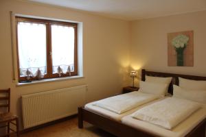 鲁斯特吉瑞尔酒店的一间卧室配有一张带白色床单的床和一扇窗户。