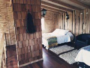琼奇Cabaña Loft del Sur Premium的卧室配有木墙内的一张床