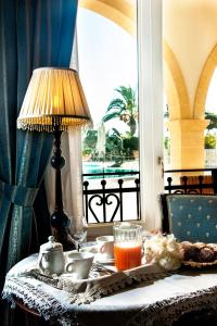 圣焦尔焦约尼科圣乔瓦尼村酒店的桌子,桌子上放着一盏灯,一盘食物,还有一扇窗户
