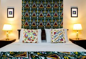 撒马尔罕Jahongir Guest House的一间卧室配有一张带床头板的床和两盏灯。