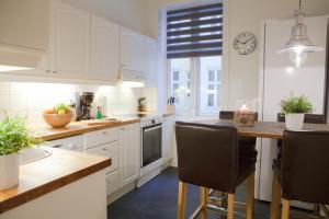 奥斯陆Vika I, As Home的厨房配有白色橱柜和桌椅