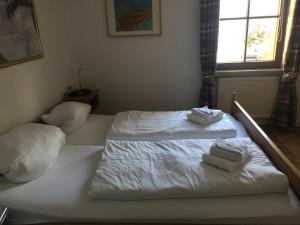 巴特欣德朗Residenz Allgäublick, Ihr Bett im Allgäu的一间卧室配有两张床、白色的床单和毛巾。