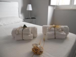 特拉尼Arco' B&B的一张带毛巾的白色床和填充动物