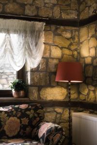 卡托劳塔翁Archontiko Emmanouilidi Suites的一间设有石墙、一盏灯和一扇窗户的房间