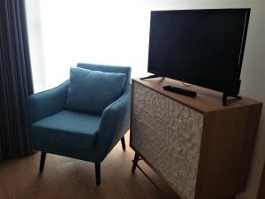 安奇奥Ansiturismo Alojamento的客厅配有椅子和梳妆台上的电视