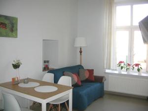 琴斯托霍瓦Studio Aleja 77的客厅配有蓝色的沙发和桌子