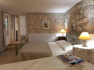木洛希尼Apartments Gabri的一间卧室设有两张床和石墙