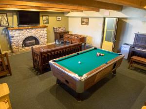 坎莫尔Canmore Alpine Hostel - Alpine Club of Canada的客房设有台球桌和壁炉。