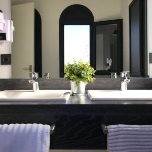 塞维利亚Uma Suites Parada del Marqués的一间带两个盥洗盆和大镜子的浴室
