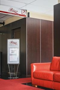马热伊基艾帕尔马酒店的墙上红色的沙发,有标志